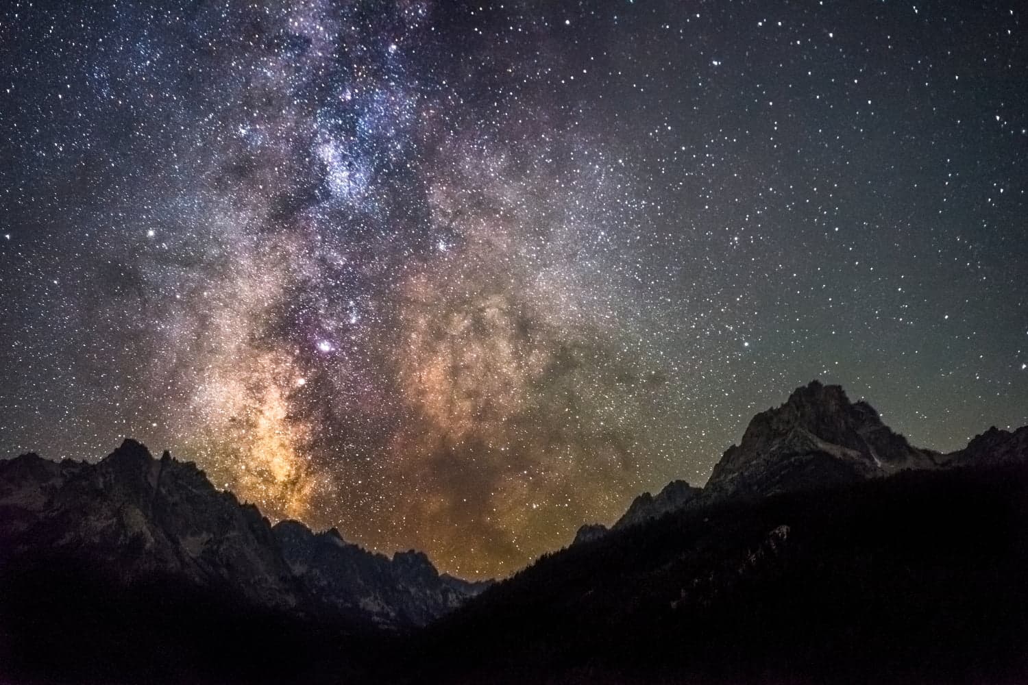 A stunning view of the Milky Way galaxy above a mountain landscape at night. A stunning view of the Milky Way galaxy above a mountain landscape at night.