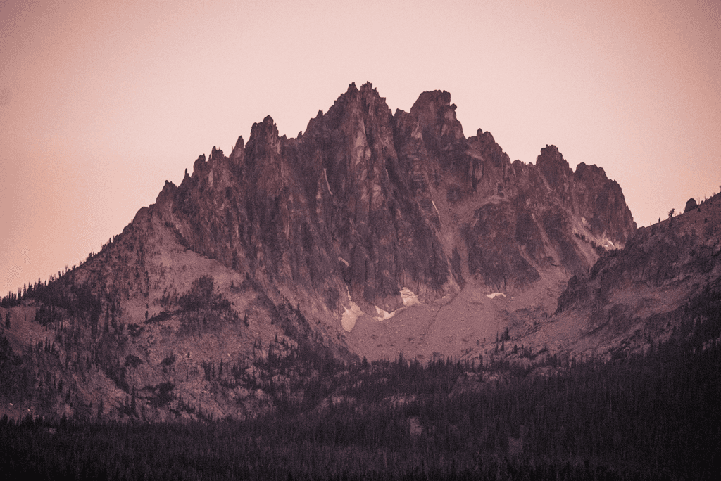 A rugged mountain peak silhouetted against a dusky sky.