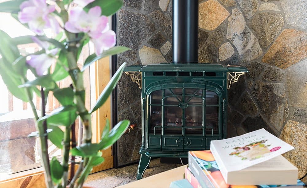 green znd pink flowers with bamboo and a green fireplace stove